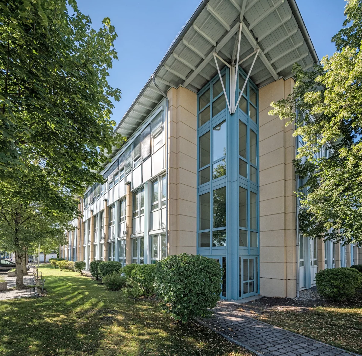 Verglastes Ecktreppenhaus mit auskragendem Dach und Vorgarten